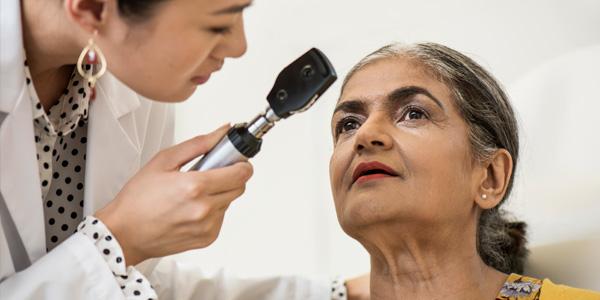 Ärztin untersucht das Auge einer Patientin