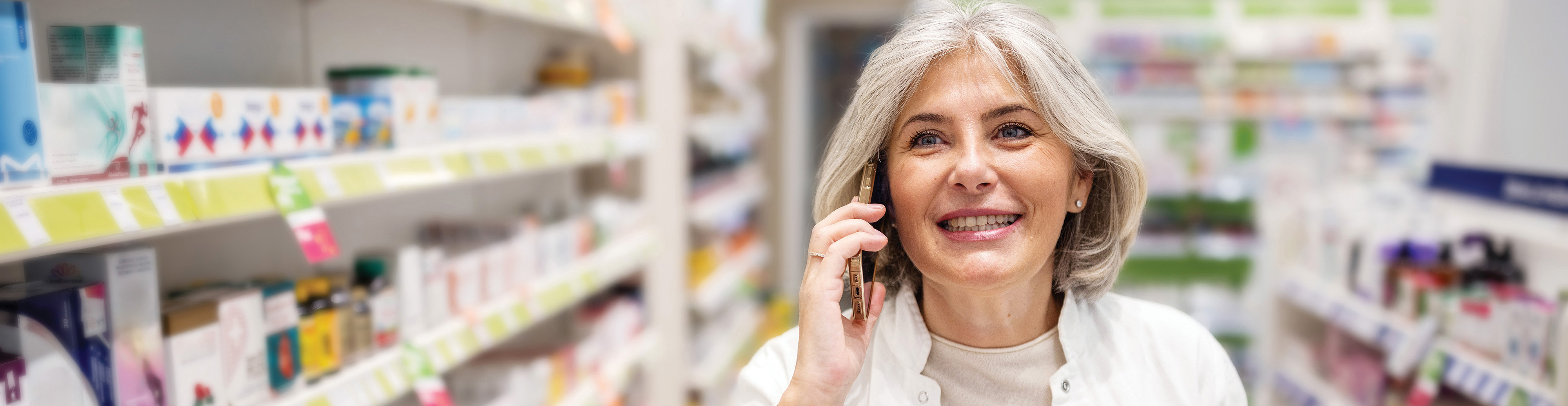 Apothekerin telefoniert in einer Apotheke