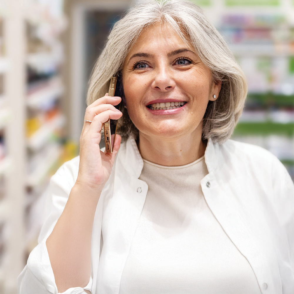 Apothekerin telefoniert in einer Apotheke